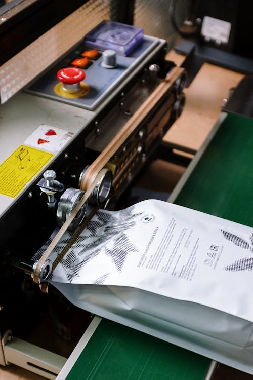 An image of a bag of coffee beans being sealed in a factory
