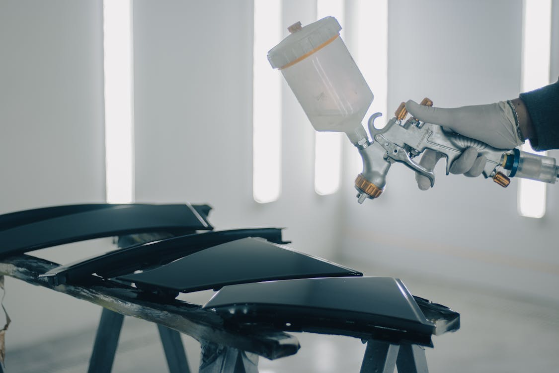  an individual spraying WPU on metal slabs