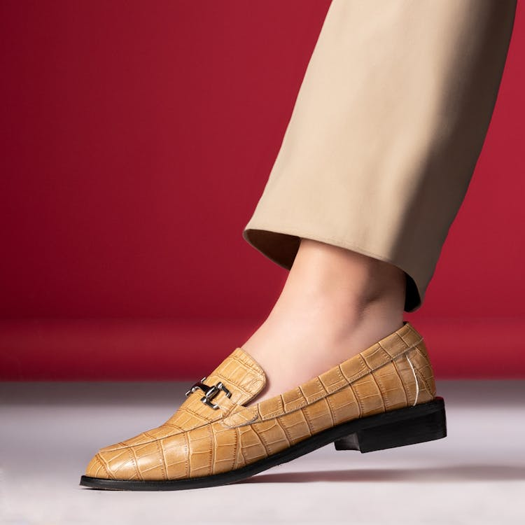 a closeup shot of a female wearing synthetic leather loafers