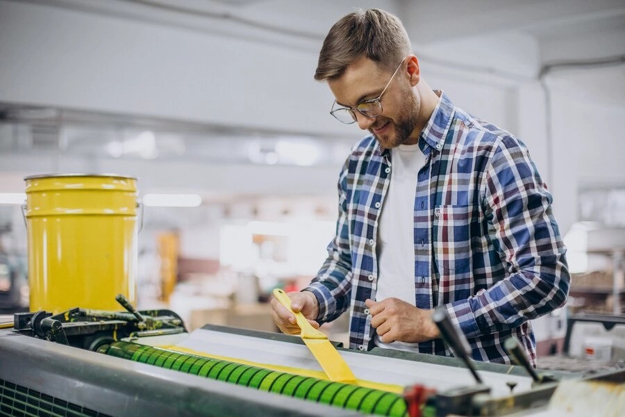 A worker coating textiles in waterborne polyurethane