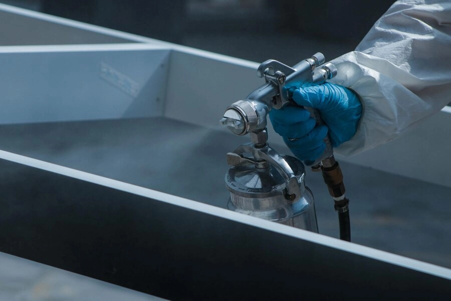 close-up of a person spray painting for a coating against corrosion